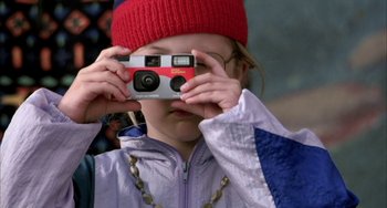 Movie still from “Eagle vs Shark” (2007), directed by Taika Waititi – A young girl taking a picture with a camera; Extreme Close Up shot, High angle