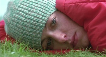 Movie still from “Eagle vs Shark” (2007), directed by Taika Waititi – A person laying in the grass wearing a hat; Extreme Close Up shot, Overhead angle