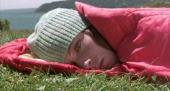 Movie still from “Eagle vs Shark” (2007), directed by Taika Waititi – A woman laying in the grass wearing a green hat; Close Up shot, Low angle