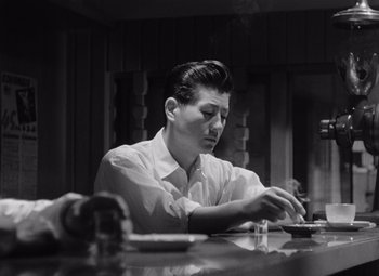A black and white photo of a man sitting at a table