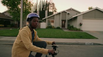 Movie still from “Earth to Echo” (2014), directed by Dave Green – A person riding a bike in front of a house; Medium shot, Low angle