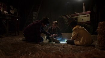 Movie still from “Earth to Echo” (2014), directed by Dave Green – A group of people sitting on the ground in the dark; Wide shot, High angle