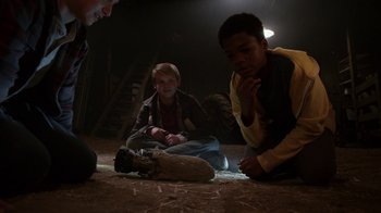 Movie still from “Earth to Echo” (2014), directed by Dave Green – A group of people sitting on the ground in a dark room; Medium shot, High angle