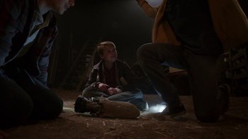 Movie still from “Earth to Echo” (2014), directed by Dave Green – A group of people sitting on the ground in the dark; Wide shot, High angle