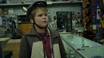 Movie still from “Earth to Echo” (2014), directed by Dave Green – A young boy wearing a helmet in a store; Close Up shot, Over the shoulder angle