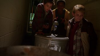 Movie still from “Earth to Echo” (2014), directed by Dave Green – A group of young people standing around a metal barrel; Medium shot, Low angle