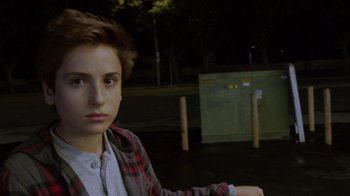 Movie still from “Earth to Echo” (2014), directed by Dave Green – A young man is sitting in a parking lot at night; Close Up shot, Over the shoulder angle