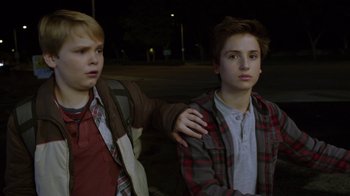 Movie still from “Earth to Echo” (2014), directed by Dave Green – Two young boys standing next to each other on the side of the road; Medium shot, Over the shoulder angle