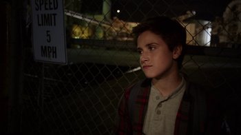Movie still from “Earth to Echo” (2014), directed by Dave Green – A young boy standing in front of a chain link fence at night; Close Up shot, High angle