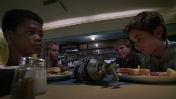 Movie still from “Earth to Echo” (2014), directed by Dave Green – A group of people sitting at a table with plates of food on it; Medium shot, High angle
