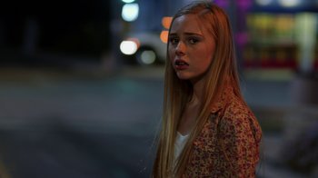 Movie still from “Earth to Echo” (2014), directed by Dave Green – A woman with long blonde hair standing on the side of the street; Close Up shot, Over the shoulder angle