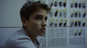Movie still from “Earth to Echo” (2014), directed by Dave Green – A young man in front of a wall of cellphones; Close Up shot, Low angle