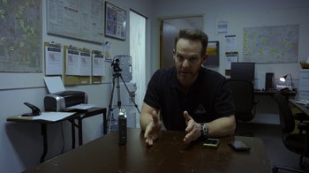Movie still from “Earth to Echo” (2014), directed by Dave Green – A man sitting at a table in front of a cell phone; Close Up shot, Over the shoulder angle