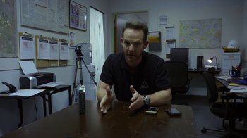 Movie still from “Earth to Echo” (2014), directed by Dave Green – A man sitting at a table in front of a cell phone; Close Up shot, Over the shoulder angle