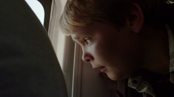 Movie still from “Earth to Echo” (2014), directed by Dave Green – A young boy looking out a plane window; Close Up shot, High angle