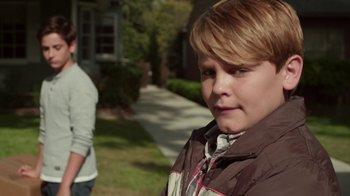 Movie still from “Earth to Echo” (2014), directed by Dave Green – A young boy standing in front of a sidewalk; Close Up shot, Over the shoulder angle