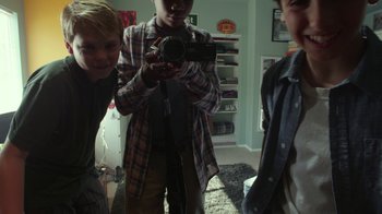 Movie still from “Earth to Echo” (2014), directed by Dave Green – A group of young men standing around a room; Medium shot, High angle