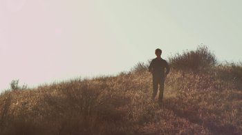 Movie still from “Earth to Echo” (2014), directed by Dave Green – A man standing on top of a grass covered hill; Extreme Wide shot, Low angle