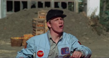 Movie still from “Eat My Dust” (1976), directed by Charles B. Griffith – A young man wearing a hat and a jacket; Close Up shot, Low angle