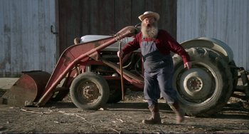 Movie still from “Eat My Dust” (1976), directed by Charles B. Griffith – An old man with a long white beard holding a stick; Wide shot, Low angle