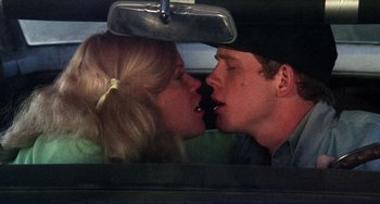 Movie still from “Eat My Dust” (1976), directed by Charles B. Griffith – A man and a woman kissing in the back of a car; Close Up shot, High angle