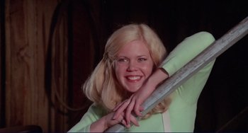 Movie still from “Eat My Dust” (1976), directed by Charles B. Griffith – A woman with blonde hair is holding on to a metal bar; Medium shot, Low angle