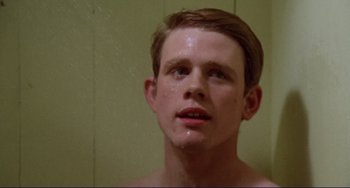 Movie still from “Eat My Dust” (1976), directed by Charles B. Griffith – A young man is looking into the camera; Close Up shot, Low angle