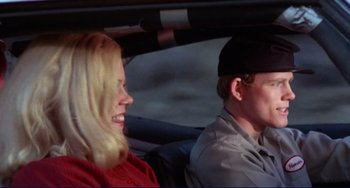 Movie still from “Eat My Dust” (1976), directed by Charles B. Griffith – A man and a woman sitting in the back of a car; Close Up shot, Over the shoulder angle