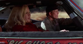 Movie still from “Eat My Dust” (1976), directed by Charles B. Griffith – A man and a woman in the back seat of a car; Medium shot, Low angle