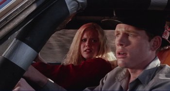 Movie still from “Eat My Dust” (1976), directed by Charles B. Griffith – A man and a woman in the back seat of a car; Close Up shot, Low angle