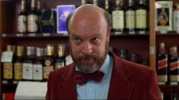 Movie still from “Eating Raoul” (1982), directed by Paul Bartel – A man with a beard wearing a red jacket and a bow tie; Close Up shot, Low angle