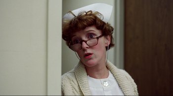 Movie still from “Eating Raoul” (1982), directed by Paul Bartel – An older woman wearing a nurse's hat and glasses; Close Up shot, Low angle