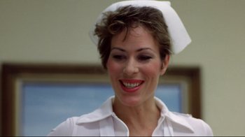 Movie still from “Eating Raoul” (1982), directed by Paul Bartel – A woman wearing a white nurse's hat smiling for the camera; Close Up shot, Low angle