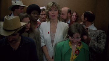 Movie still from “Eating Raoul” (1982), directed by Paul Bartel – A group of people standing in a room; Medium shot, Low angle
