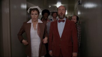 Movie still from “Eating Raoul” (1982), directed by Paul Bartel – A group of people standing in a hallway; Medium shot, Low angle