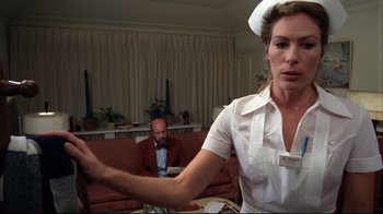 Movie still from “Eating Raoul” (1982), directed by Paul Bartel – A woman in a nurse's uniform is holding her hand out to a man in a suit; Medium shot, Low angle