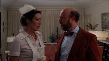 Movie still from “Eating Raoul” (1982), directed by Paul Bartel – A man and a woman are standing next to each other; Close Up shot, Over the shoulder angle