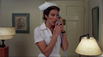 Movie still from “Eating Raoul” (1982), directed by Paul Bartel – A woman in a nurse's uniform talking on a phone; Medium shot, Low angle