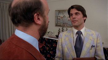 Movie still from “Eating Raoul” (1982), directed by Paul Bartel – A man in a suit talking to another man in a suit; Medium shot, Over the shoulder angle