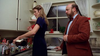 Movie still from “Eating Raoul” (1982), directed by Paul Bartel – A man and a woman in the kitchen preparing a meal; Medium shot, Low angle