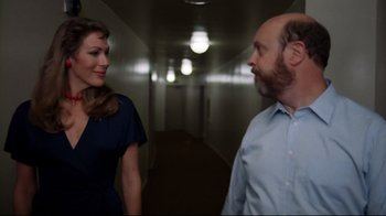 Movie still from “Eating Raoul” (1982), directed by Paul Bartel – A man and a woman are walking in a hallway; Medium shot, Over the shoulder angle