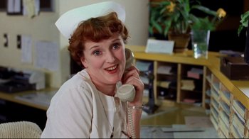 Movie still from “Eating Raoul” (1982), directed by Paul Bartel – A woman in a nurse's uniform talking on a phone; Close Up shot, Low angle