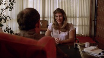 Movie still from “Eating Raoul” (1982), directed by Paul Bartel – A woman sitting in front of a man at a table; Medium shot, Over the shoulder angle
