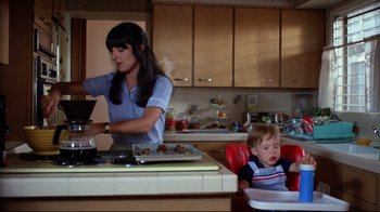 Movie still from “Eating Raoul” (1982), directed by Paul Bartel – A woman and a child in a kitchen; Medium shot, Low angle