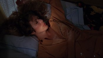 Movie still from “Eating Raoul” (1982), directed by Paul Bartel – A woman laying in bed with her eyes closed; Medium shot, Overhead angle