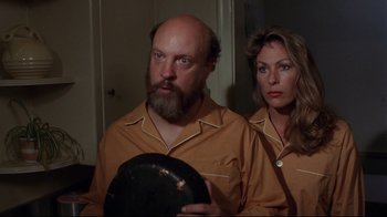 Movie still from “Eating Raoul” (1982), directed by Paul Bartel – A man and a woman standing next to each other; Medium shot, Low angle