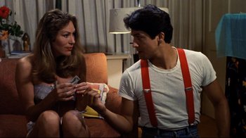 Movie still from “Eating Raoul” (1982), directed by Paul Bartel – A man and a woman sitting on a couch; Medium shot, Over the shoulder angle