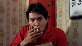 Movie still from “Eating Raoul” (1982), directed by Paul Bartel – A man smoking a cigarette in front of a mirror; Close Up shot, Low angle