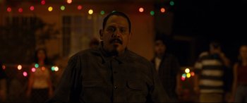 Movie still from “El Chicano” (2018), directed by Ben Hernandez Bray – A person with a beard and mustache; Medium shot, Over the shoulder angle