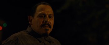 Movie still from “El Chicano” (2018), directed by Ben Hernandez Bray – A person wearing a suit and tie; Close Up shot, Over the shoulder angle